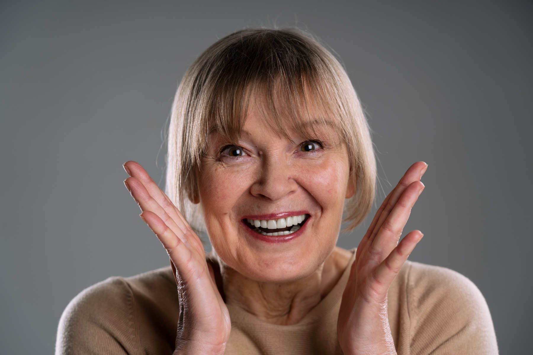 Une femme souriant avec des prothèses dentaires.