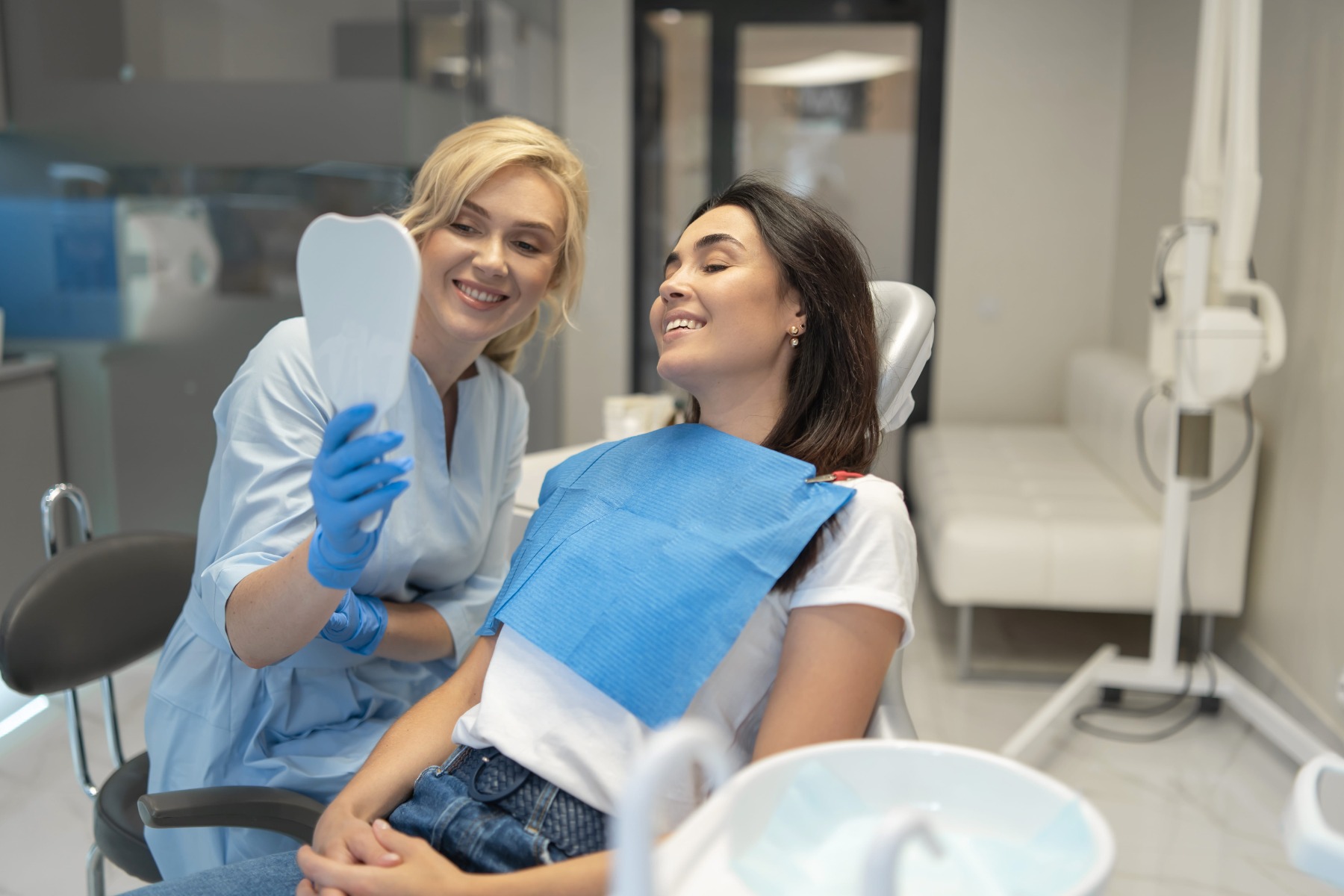 Une dentiste souriante avec une patiente ravie.